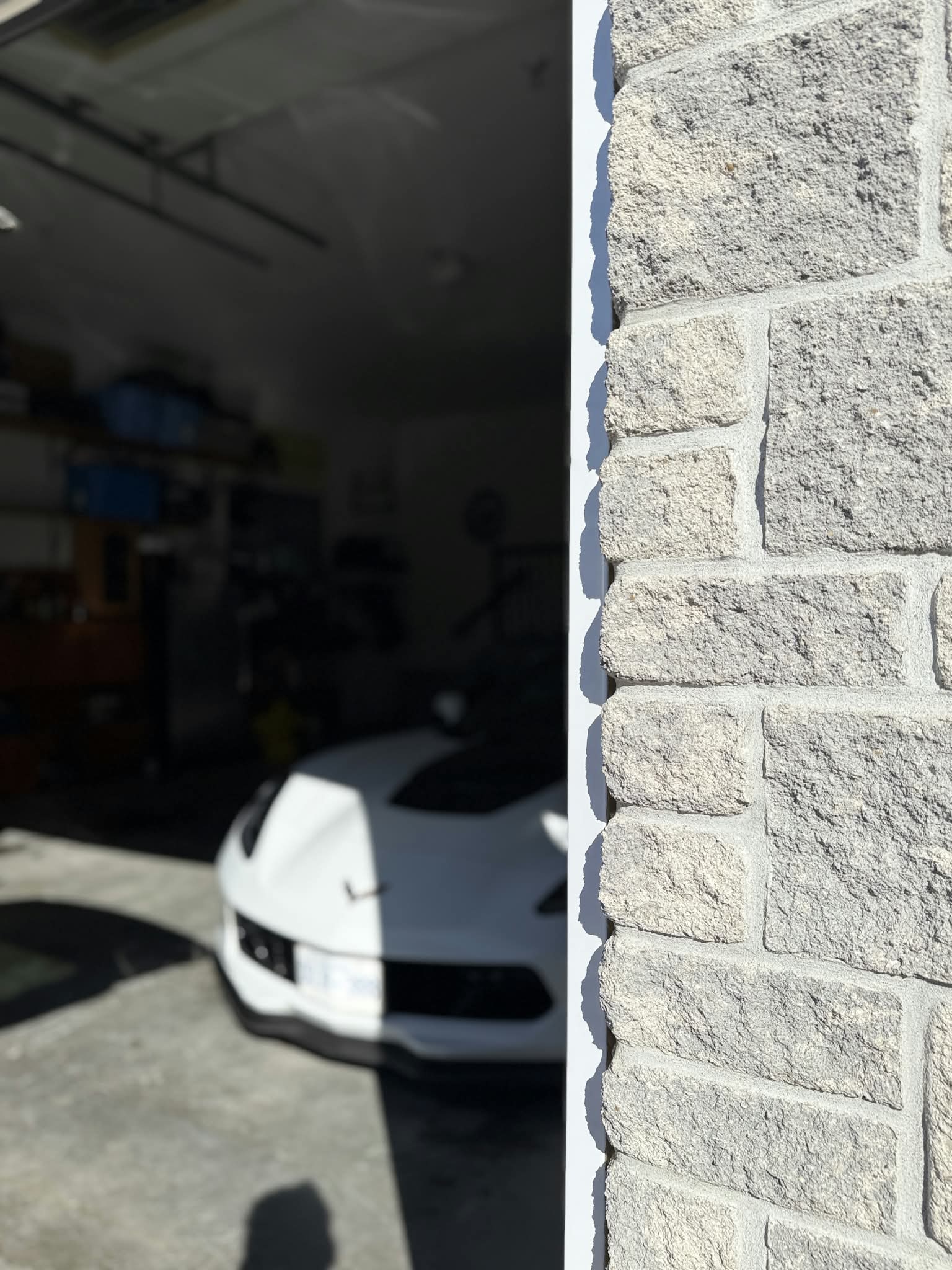 White Corvette viewed from the entrance of a garage