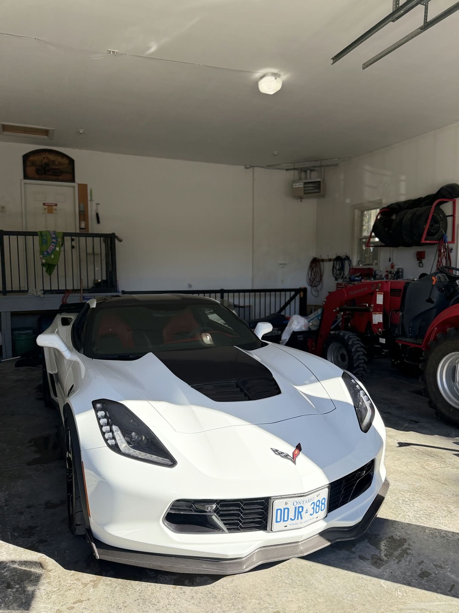 Front view of a white Corvette parked in a garage