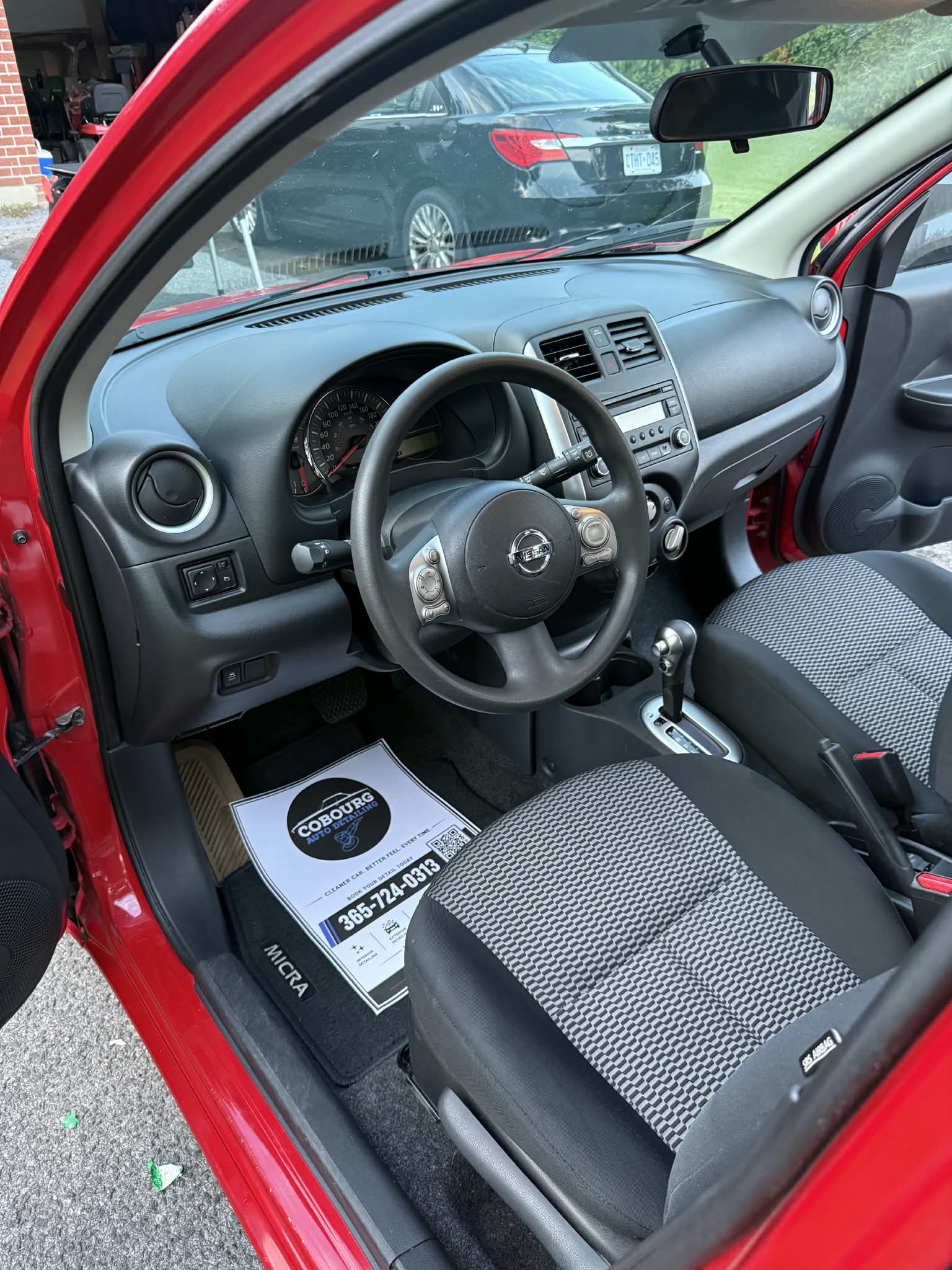Toyota front cloth seat and dashboard viewed through the open driver door