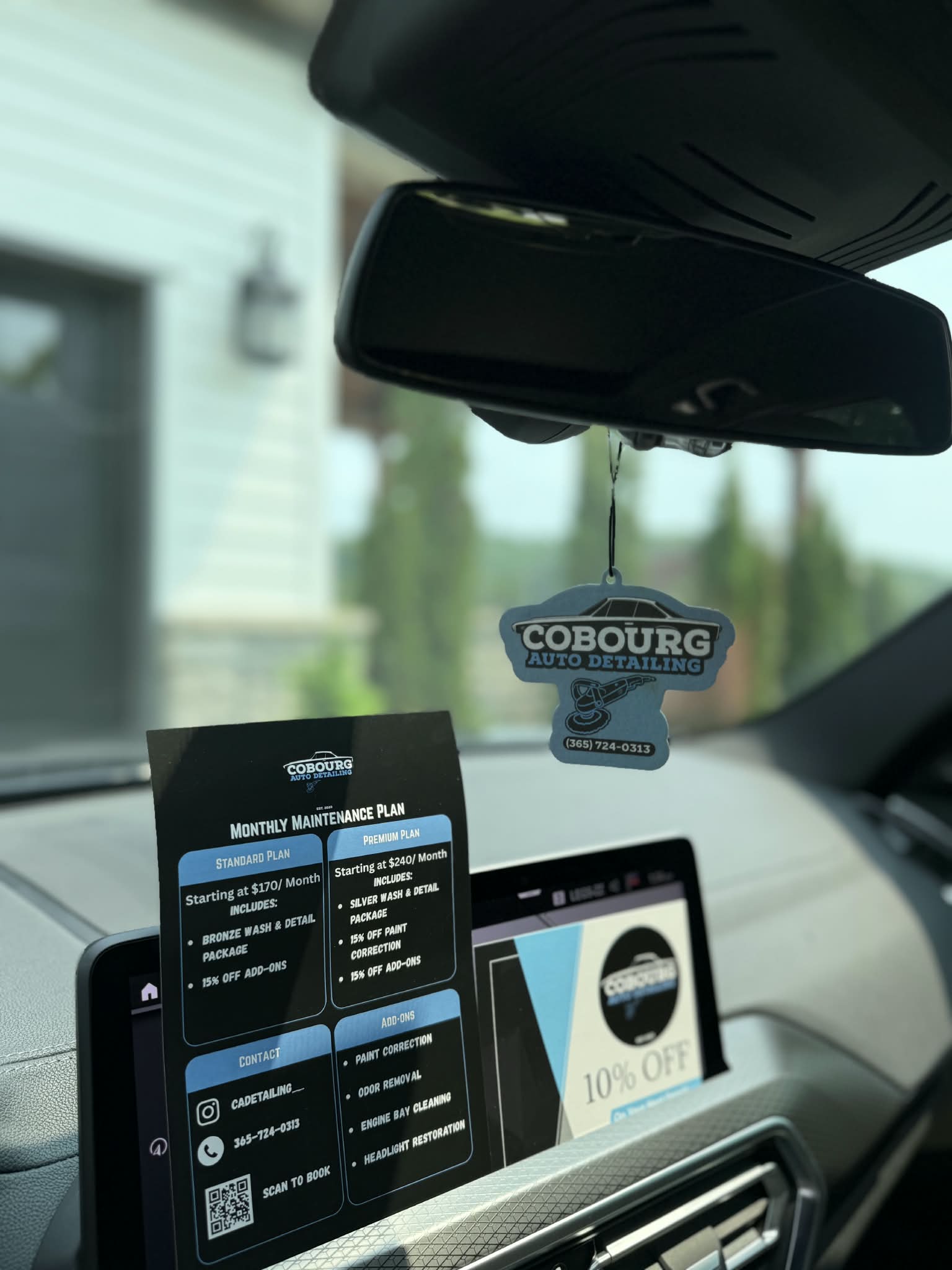Cobourg Auto Detailing air freshener and business cards inside a vehicle